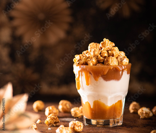 Delicious caramel milkshake with sweet popcorn on a dark background.