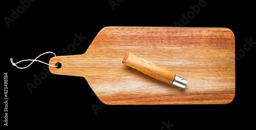Wooden cutting board and pocket knife isolated on black