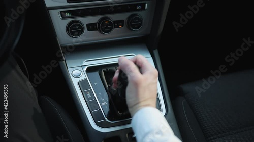Driver's adm includes mode Drive on the gear lever automatic transmission of the luxury car interior parts. Business man in suit hand control the stick shift transmission. photo