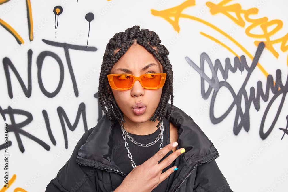 Photo of surprised female rapper with braids makes cool gesture looks ...