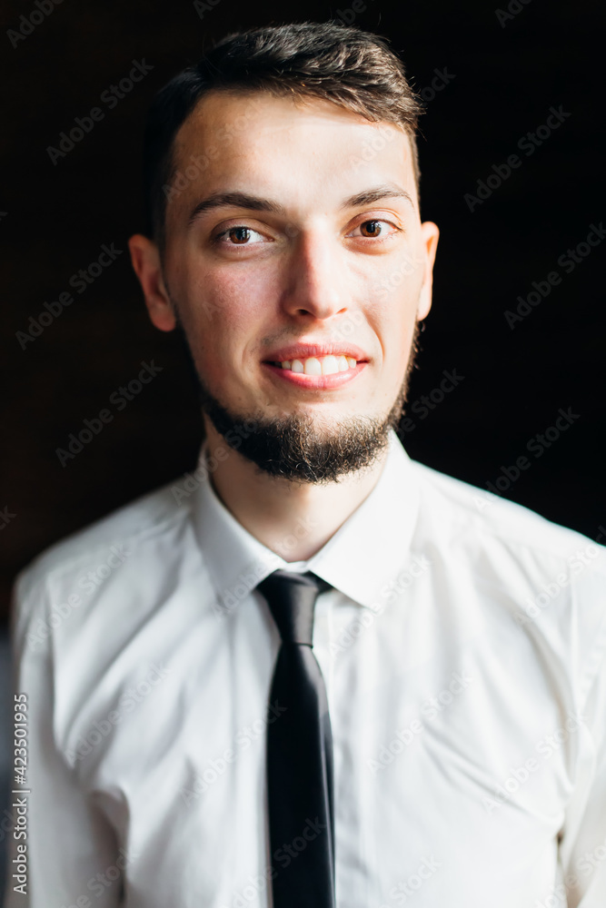 Young and stylish groom with a beard is smiling. Morning preparation of the wedding ceremony. Young and stylish groom with a beard is smiling. Morning preparation of the wedding ceremony.