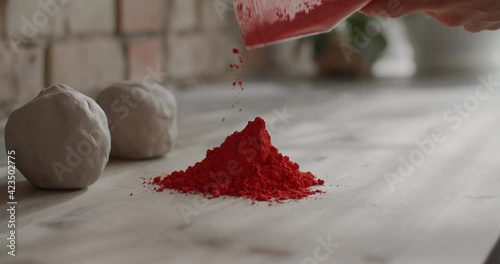 Ceramist pours dry dye for kneading colored clay, nerikomi pottery, potter's workshop, 4k 60p Prores HQ 10 bit photo