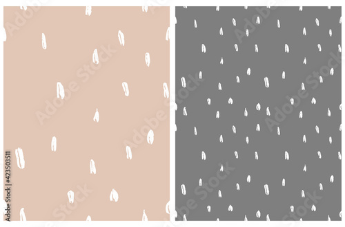 Simple Irregular Geometric Seamless Vector Patterns. White Hand Drawn Spots Isolated on a Light Brown and Dark Gray Background. Cute Dotted Layout ideal for Fabric, Textile. Abstract Doodle Print.