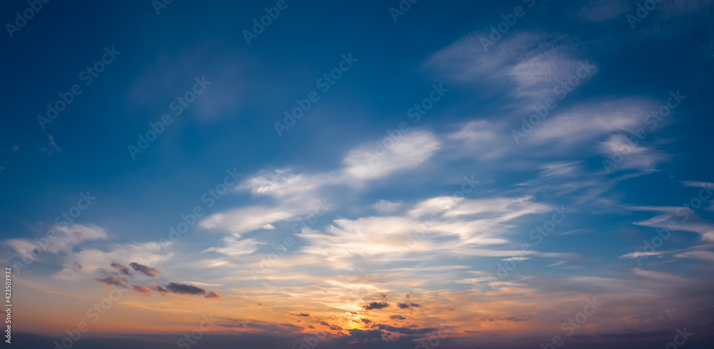 Picturesque sunset sky with clouds illuminated with dramatic sunlight.