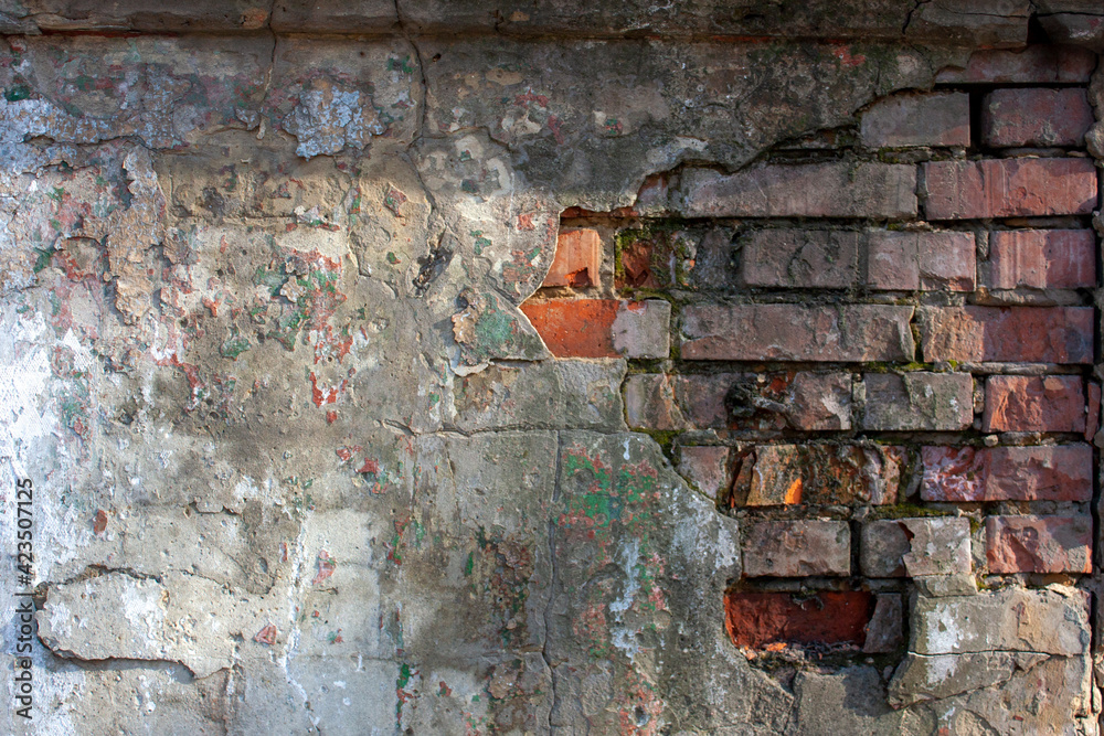 White and red. Plaster on a brick wall, close-up. A fragment of the old brickwork is visible from under the plaster. Potholes and defects in red brick. White and red. Plaster on a brick wall, close-up. A fragment of the old brickwork is visible from under the plaster. Potholes and defects in red brick.