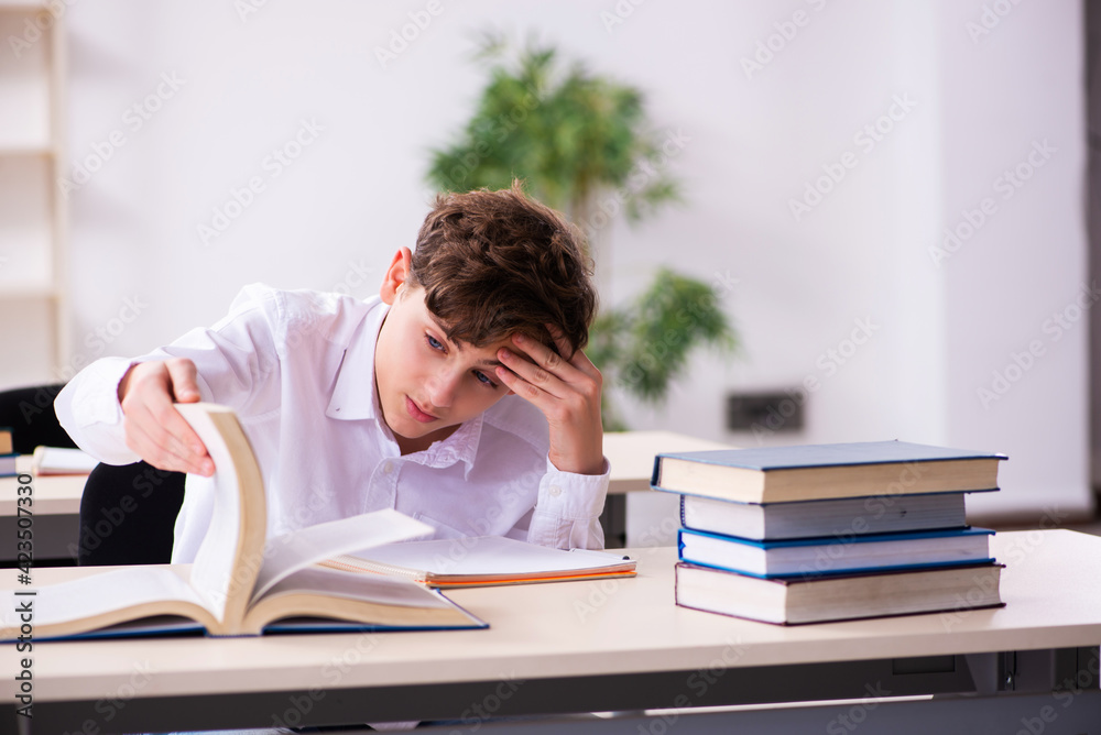 Schoolboy preparing for exams in the classroom Schoolboy preparing for exams in the classroom