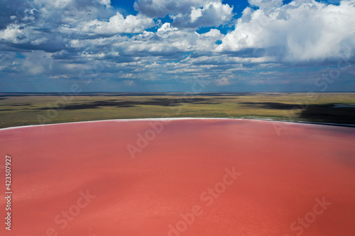 sky with clouds and pink salt lake in the steppe