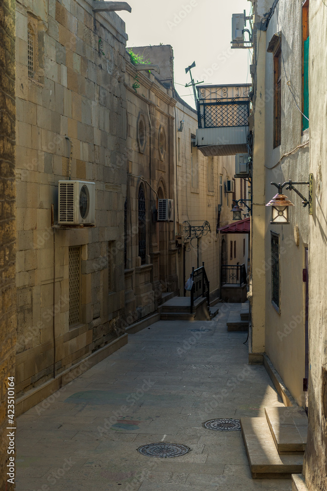 Fototapeta premium Empty street in old city Icheri Sheher of Baku, Azerbaijan. Architecture of Old city Baku. Inner City buildings.