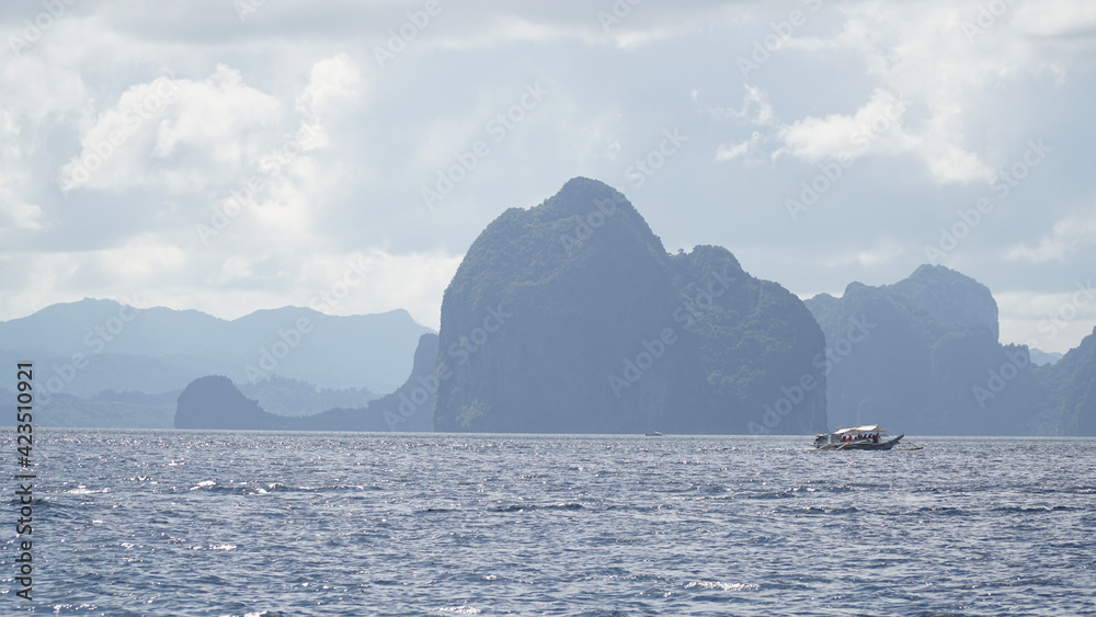 Green lush karst mountains rising out of the ocean on Palawan Island near El Nido, Philippines Green lush karst mountains rising out of the ocean on Palawan Island near El Nido, Philippines