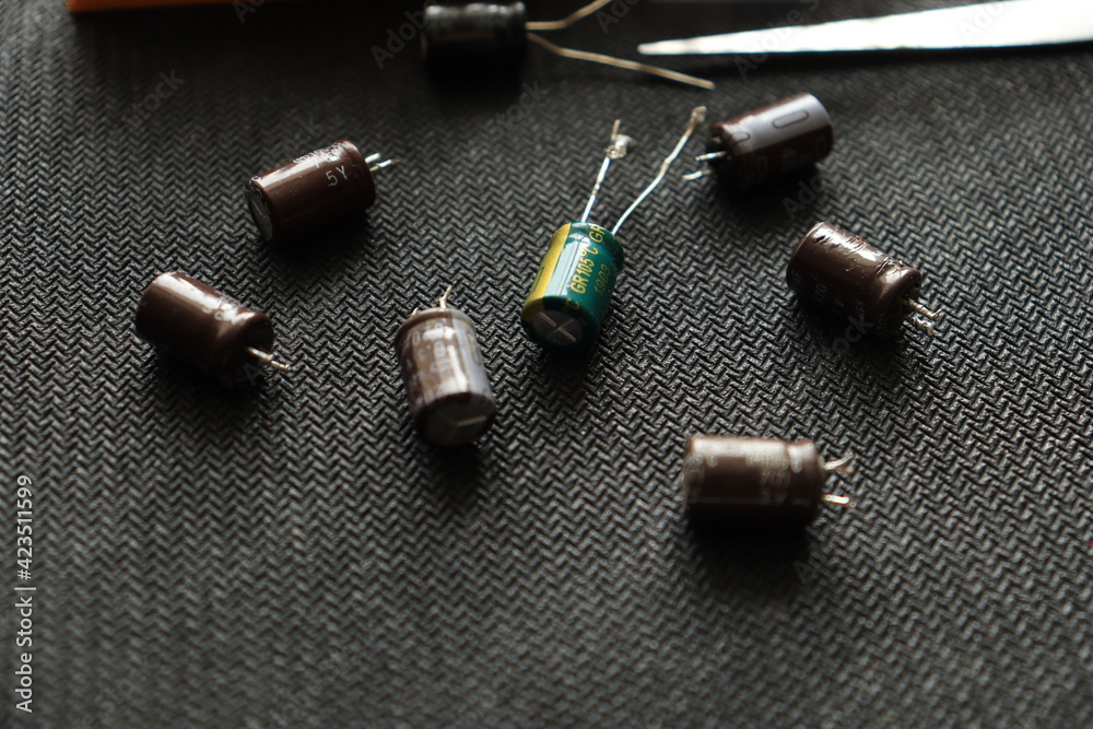Black background. Isolated capacitor, used in electronic device. Electronic parts concept. Black background. Isolated capacitor, used in electronic device. Electronic parts concept.