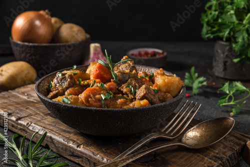 Konstfotografi Irish stew made with beef, potatoes, carrots and herbs in a plate with cutlery o