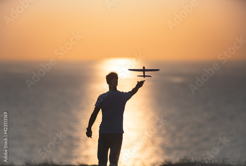 The man launches the toyful plane at the sea shore photo