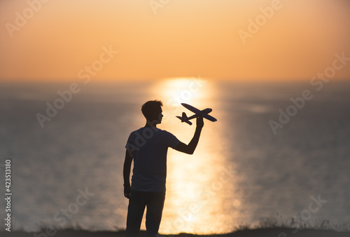 The man launches the toyful plane at the sea shore photo