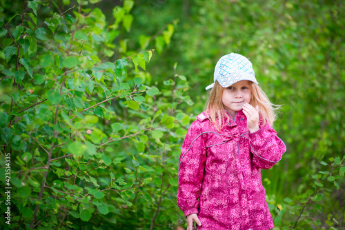 blonde girl in pink jacket outdoors. selective focus