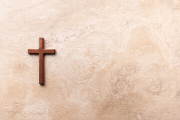Wooden cross on marble background. Reminder of Jesus sacrifice and Christ resurrection. Easter passover. Palm sunday, Good friday concept. Christianity symbol and faith.