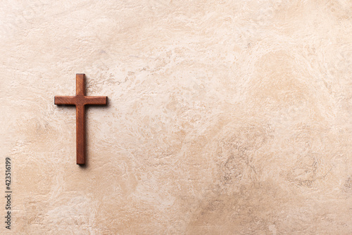 Wooden cross on marble background. Reminder of Jesus sacrifice and Christ resurrection. Easter passover. Palm sunday, Good friday concept. Christianity symbol and faith.
