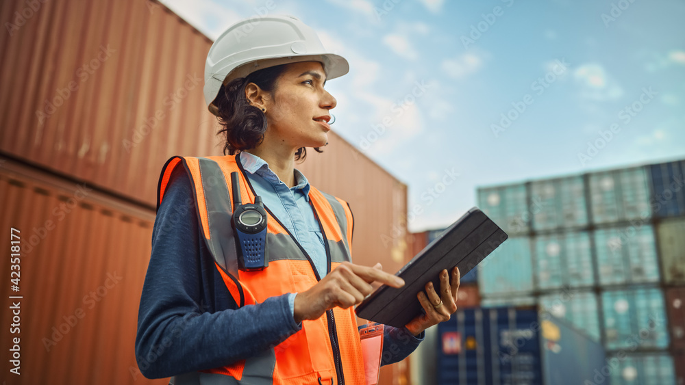 Smiling Portrait of a Beautiful Latin Female Industrial Engineer in White Hard Hat, High-Visibility Vest Working on Tablet Computer. Inspector or Safety Supervisor in Container Terminal. - obrazy, fototapety, plakaty 