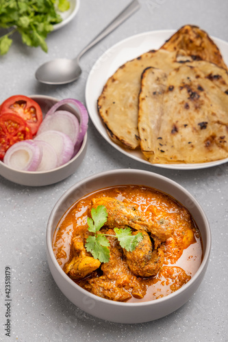 spicy gravy chicken served in a bowl with butter naan