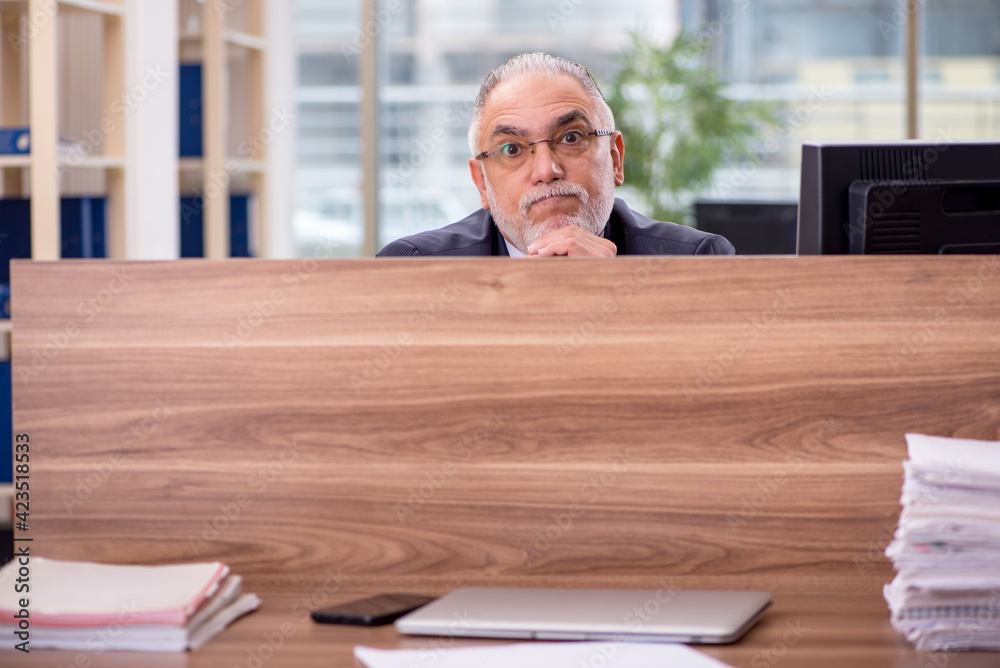 Fototapeta premium Old male employee sitting in the office