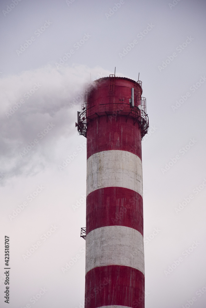Smoking chimney of a factory or factory on the background of the sky