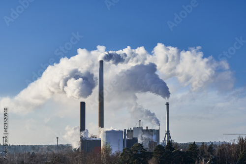 Obraz na płótnie Close-up view of CHP plant pipes with smoke in the sunny day. w salonie