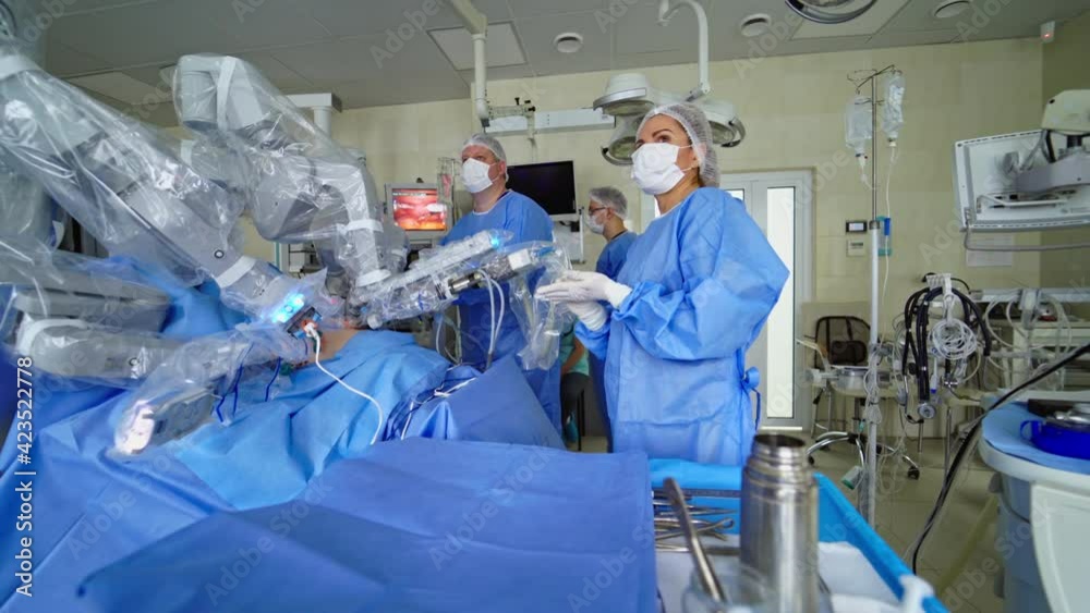 Operating room with hi-tech equipment. Surgery with medical robot in clinic. Assistant prepares sterile instruments during surgery. Operating room with hi-tech equipment. Surgery with medical robot in clinic. Assistant prepares sterile instruments during surgery.