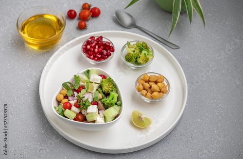 fresh green salad served in a white bowl with beans  legumes  and pomegranate seeds