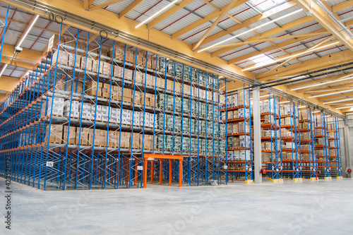 Interior view of a warehouse with racks, pallets, goods, forklifts