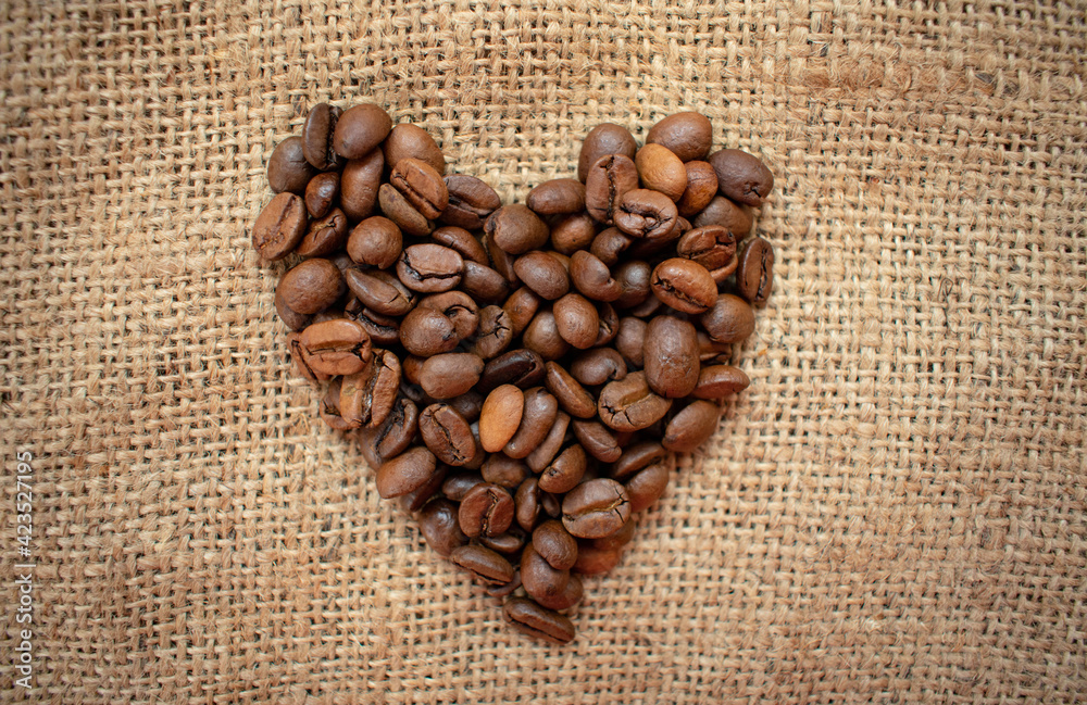 The coffee beans are laid out in the shape of a heart.