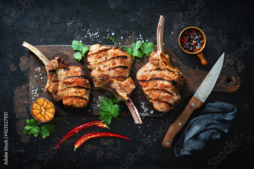 Fotomurale Grilled veal meat ribs cutlets with ingredients on rustic dark background