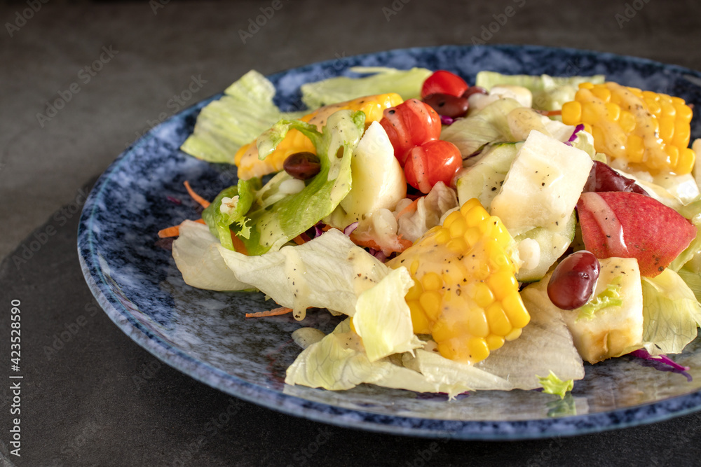 Fresh vegetable salad and fruit salad on the black stone table Fresh vegetable salad and fruit salad on the black stone table