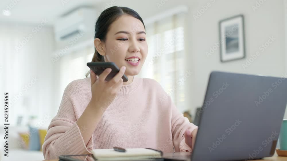 Young happy attractive beautiful asia female staff laugh talk on mobile phone relax comfort sit work on desk table at home. Remotely work on distance job telesale or secretary career for business. Young happy attractive beautiful asia female staff laugh talk on mobile phone relax comfort sit work on desk table at home. Remotely work on distance job telesale or secretary career for business.