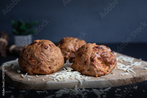 Three flax flour bagels, home baked, mozzarella cheese, wooden board, cloth, selective focus, dark background. Natural light.