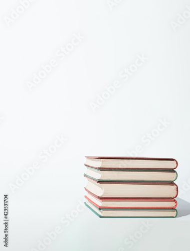 Simple cpmposition of  hardback books on white background. Minimal concept. Good copy space.