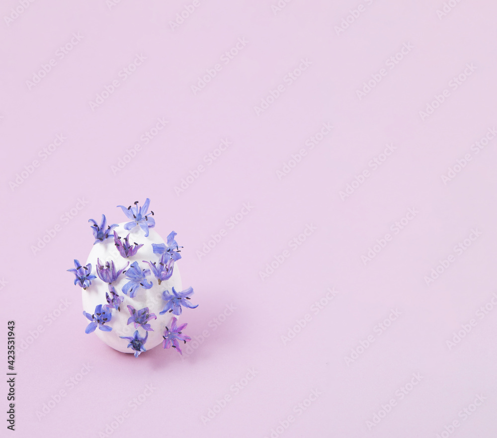 Creative layout with white egg and wild violet flowers. Minimal Easter concept. - obrazy, fototapety, plakaty 