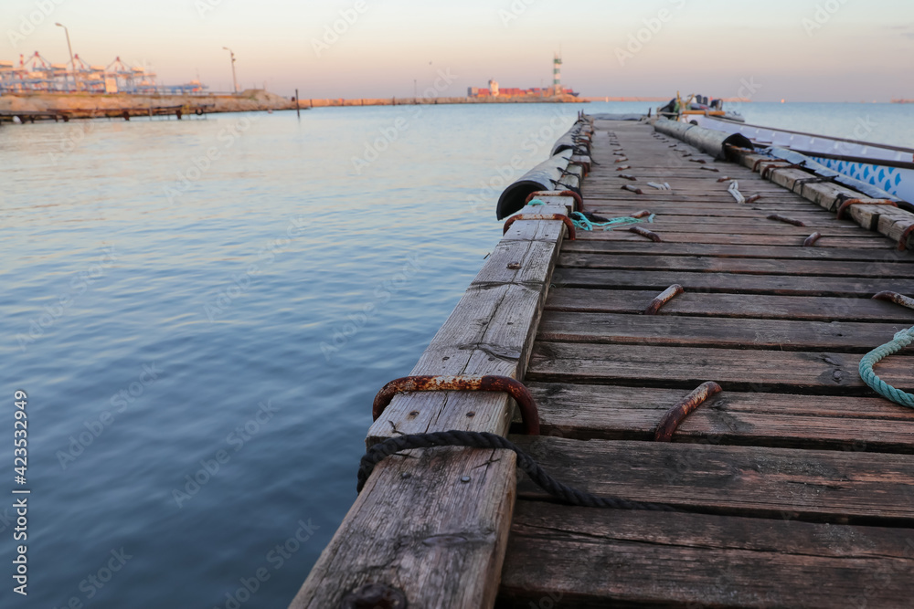 Fototapeta premium Wooden pier with blue sea. Wood floor or terrace beside the blue crystal clear water and a rope.
