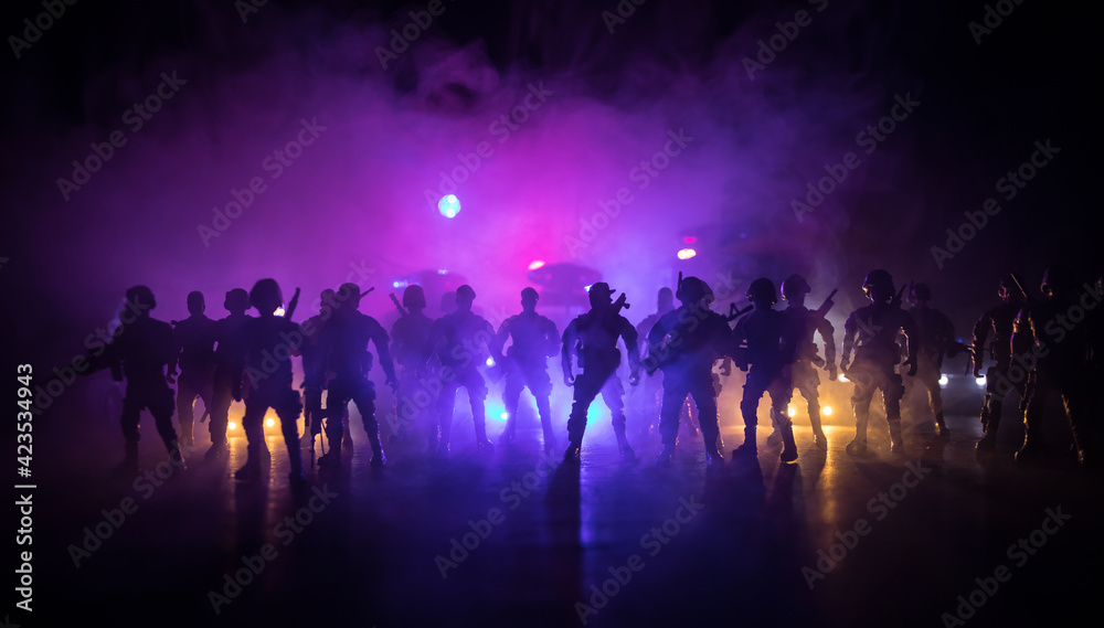 Anti-riot police give signal to be ready. Government power concept. Police in action. Smoke on a dark background with lights. Blue red flashing sirens. Dictatorship power Anti-riot police give signal to be ready. Government power concept. Police in action. Smoke on a dark background with lights. Blue red flashing sirens. Dictatorship power