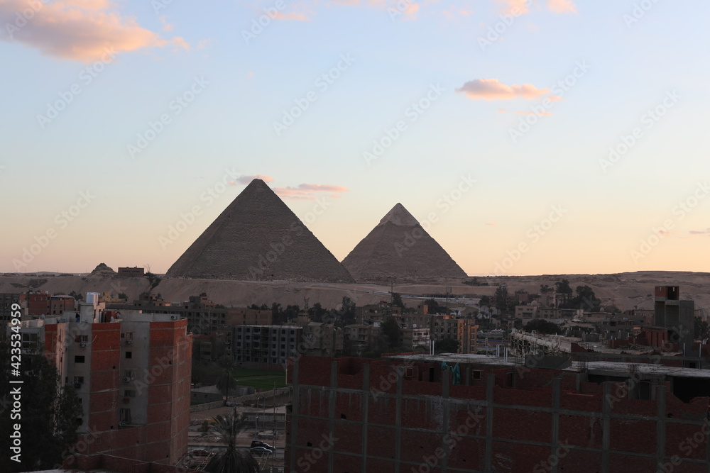 The great pyramids of giza. Tourists in the historic city. Beautiful landscape at sunset. View of walking people on a cloudy morning. Travel to African continent. UNESCO World Heritage Site. The great pyramids of giza. Tourists in the historic city. Beautiful landscape at sunset. View of walking people on a cloudy morning. Travel to African continent. UNESCO World Heritage Site.
