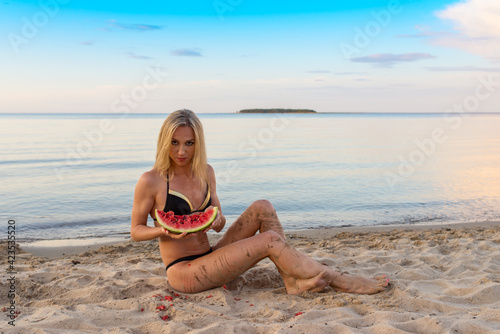 happy girl in black bikini relaxing on the sand