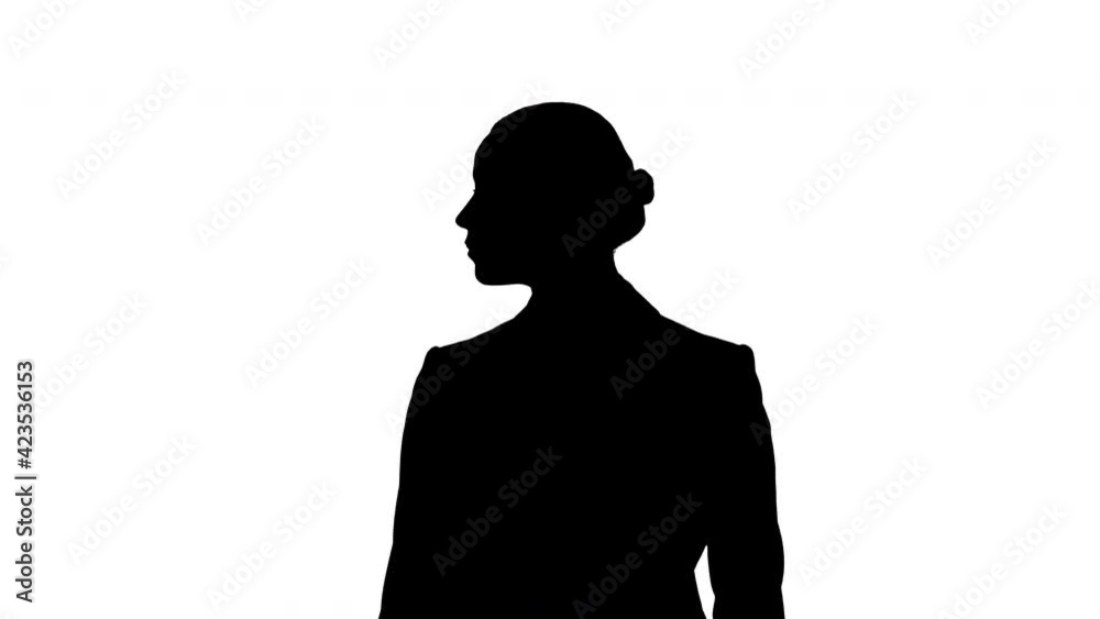 Silhouette Young woman walking through museum or exhibition looking to the sides.