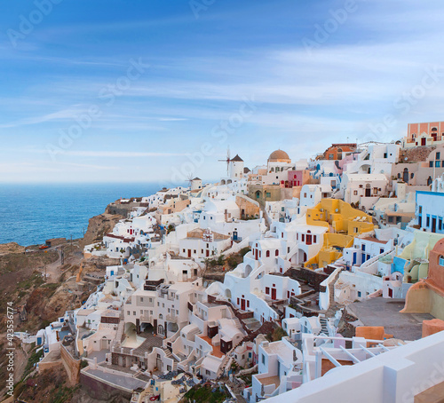 Panoramic beautiful view of Oia town on Santorini island, Cyclades, Greece. Traditional famous white houses, windmills and churches over the Caldera in Aegean sea