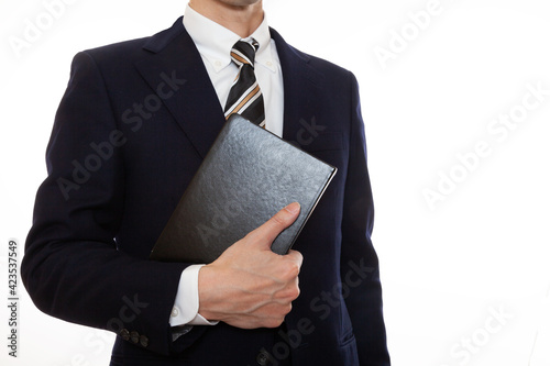 手に本を持ったビジネスパーソン