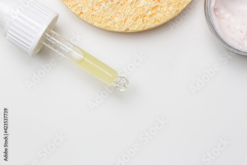 Nourishing and hydrating facial serum, antirid cream and facial sponge, top view with copy space.