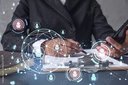 Fototapeta Naklejka Na Ścianę i Meble -  African American businesswoman signing the contract to boost her career and gain new opportunities in personal growth. Checking the detail of the deal at smartphone. Social media hologram icons