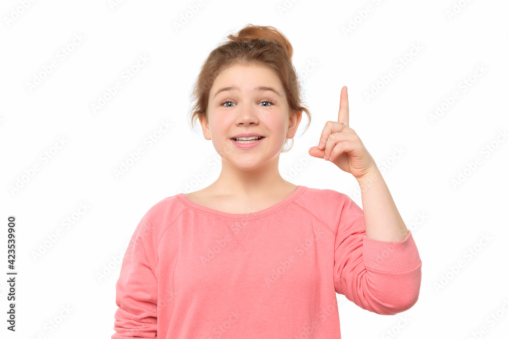 close up pretty teen girl with hair bun showing index finger, says: I have an idea. Eureka, solution sign concept close up pretty teen girl with hair bun showing index finger, says: I have an idea. Eureka, solution sign concept