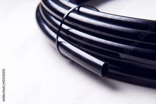 Drip irrigation system close-up. Fragment of a drip irrigation hose in a roll. Tied roll of irrigation hose.
