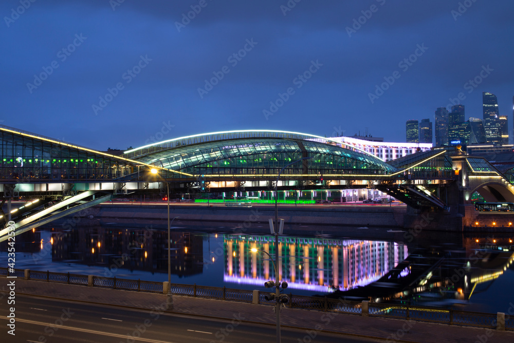View of the colorful Bogdan Khmelnitsky bridge illuminated at night reflecting in the Moskova river at night