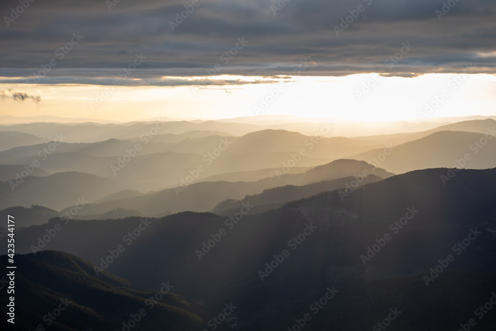 view of sunset above mountains peak view of sunset above mountains peak