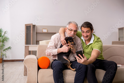 Two men with dog at home