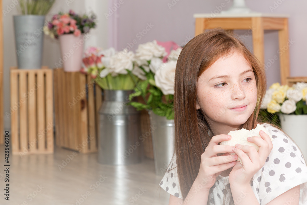 Portrait little teen girl in white blouse eating sandwich and sitting on the floor in bedroom with pleasure and looking at camera smiling. Portrait little teen girl in white blouse eating sandwich and sitting on the floor in bedroom with pleasure and looking at camera smiling.